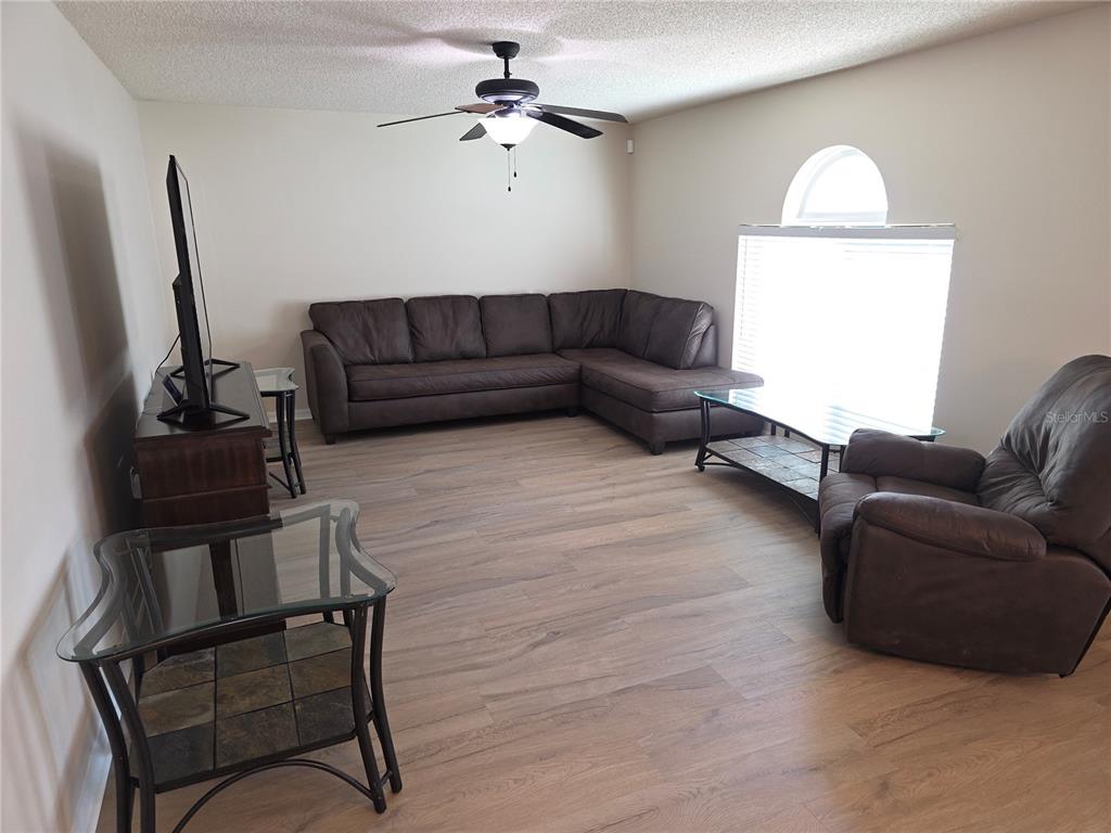 8388 Maltby Road Spring Hill, FL 34606 - Photo 3 of 28 a living room with furniture a couch and a flat screen tv