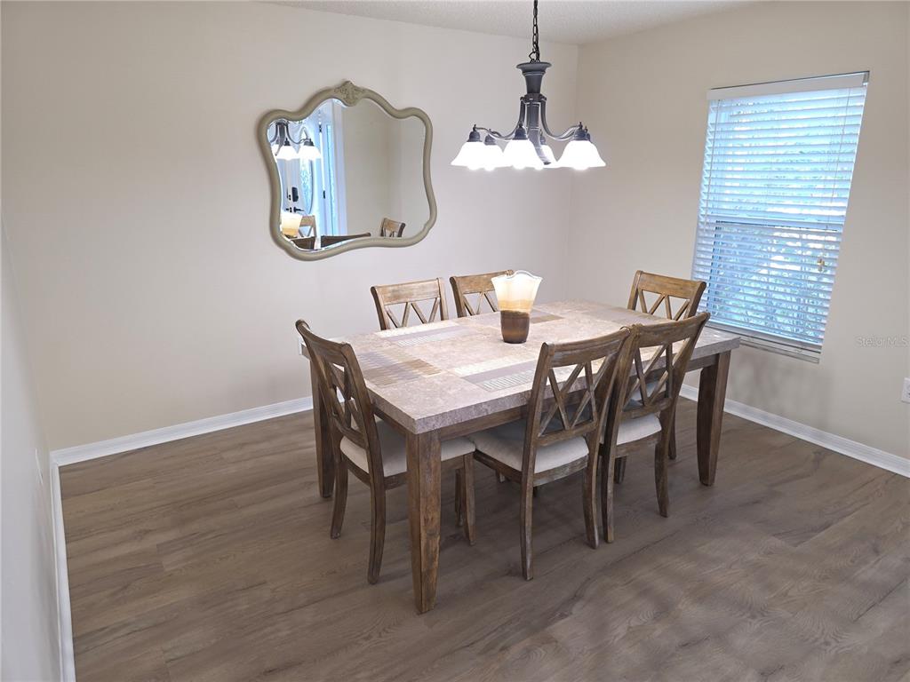 8388 Maltby Road Spring Hill, FL 34606 - Photo 8 of 28 a view of a dining room with furniture and chandelier