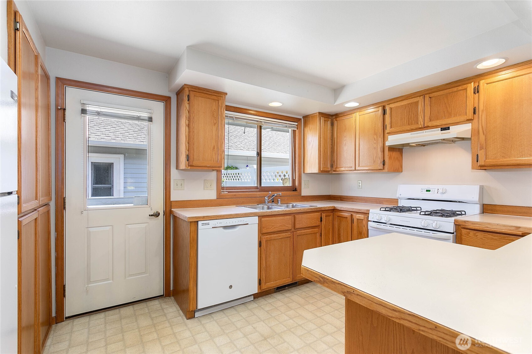 1843 Main Street, Unit G2 Lynden, WA 98264 - Photo 7 of 30 a kitchen with stainless steel appliances granite countertop a stove a sink dishwasher and a refrigerator with wooden cabinets