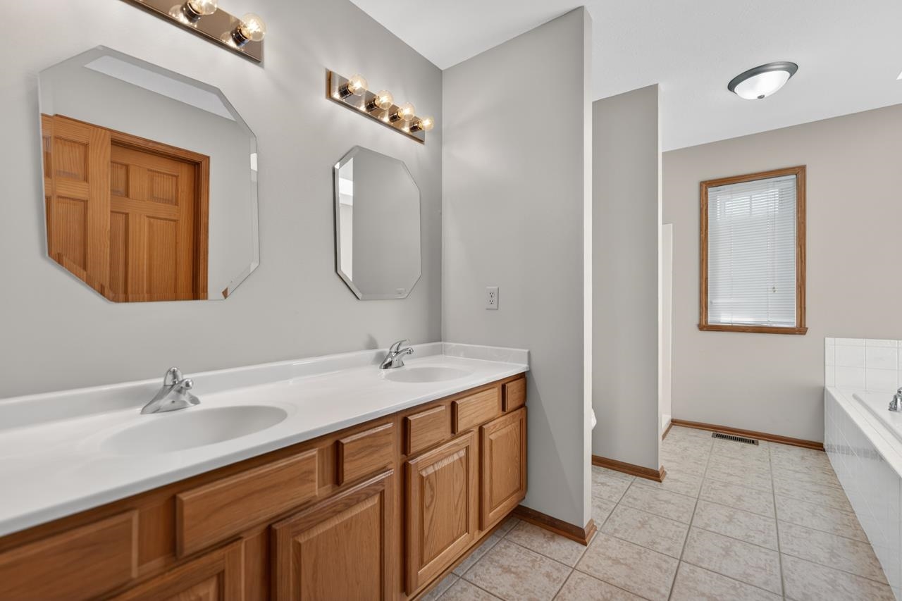 676 Elberon Way Roscoe, IL 61073 - Photo 19 of 30 a bathroom with a double vanity sink and a mirror