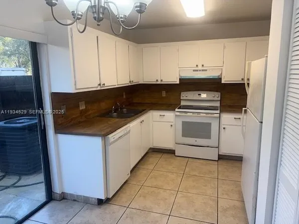 a kitchen with granite countertop a stove a sink a microwave and cabinets