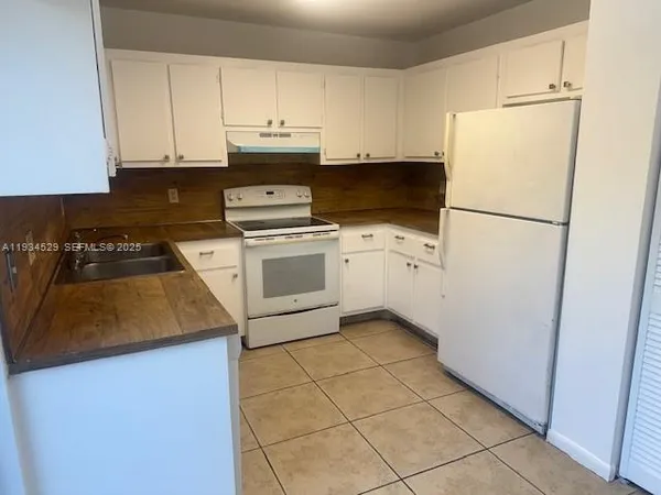 a kitchen with a white cabinets and white appliances