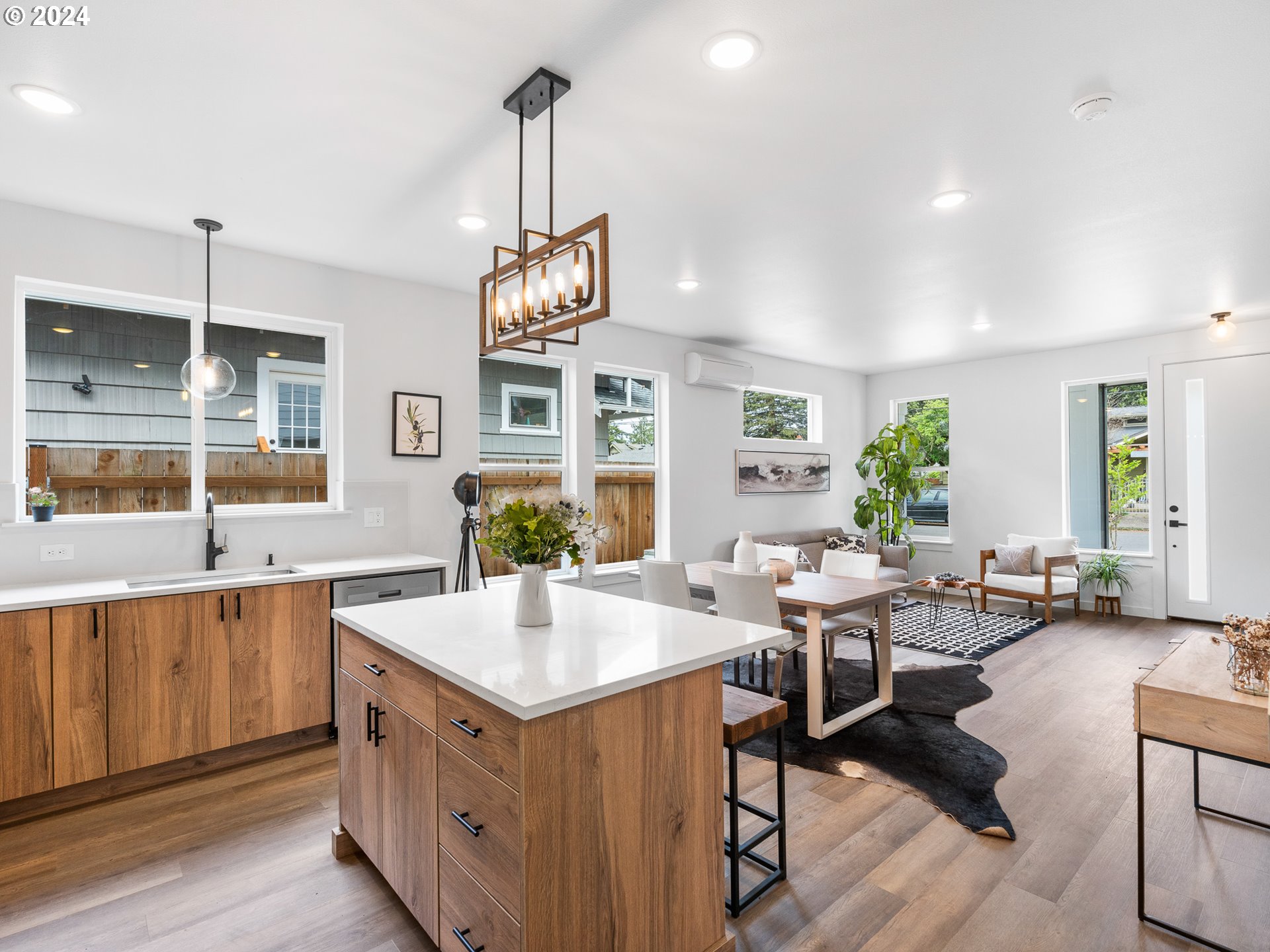 7740 Southeast Long Street, Unit A Portland, OR 97206 - Photo 12 of 23 a open kitchen with stainless steel appliances granite countertop a sink dishwasher a stove and white cabinets with wooden floor