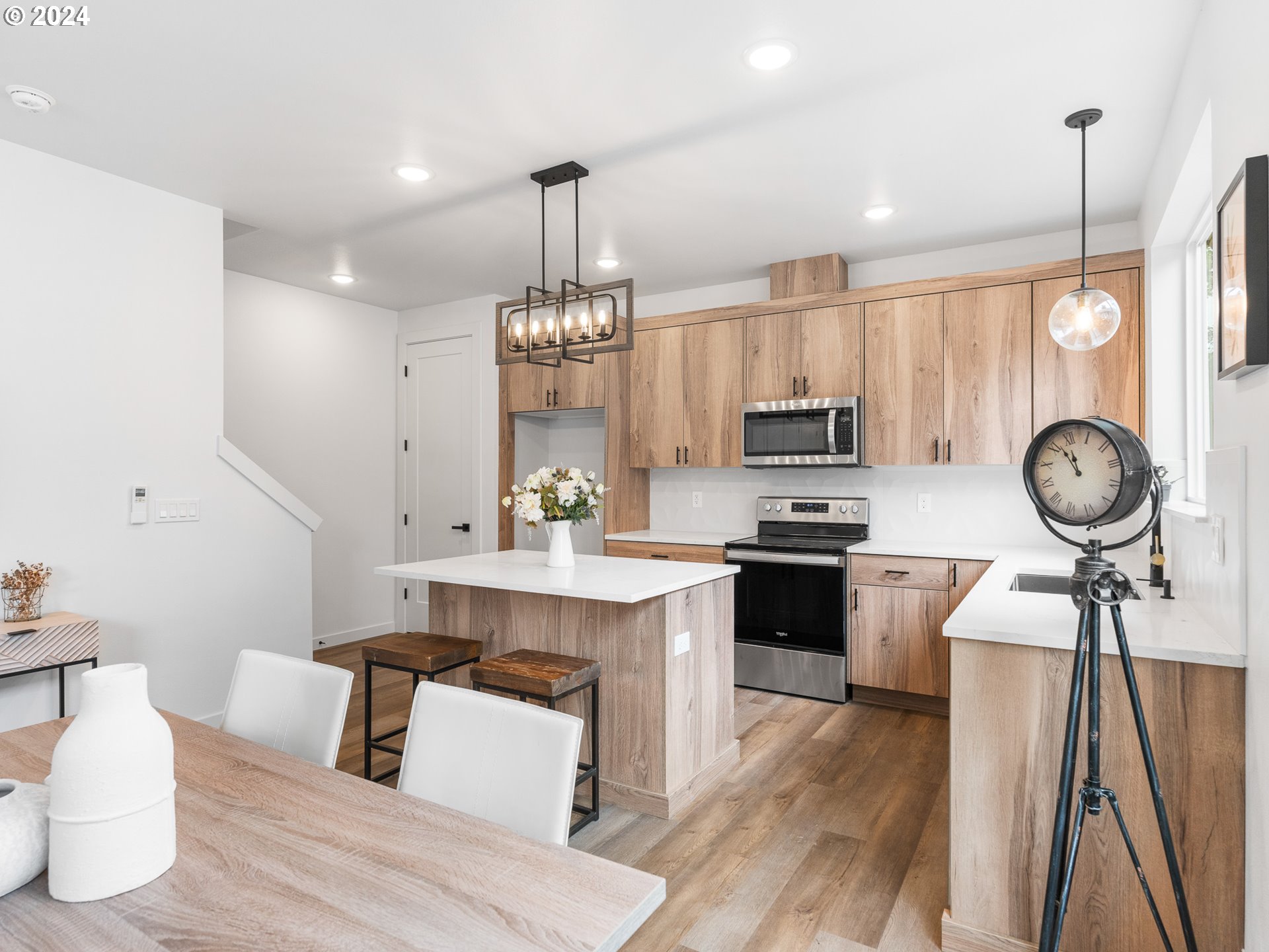 7740 Southeast Long Street, Unit A Portland, OR 97206 - Photo 9 of 23 a kitchen with stainless steel appliances a dining table chairs stove and cabinets