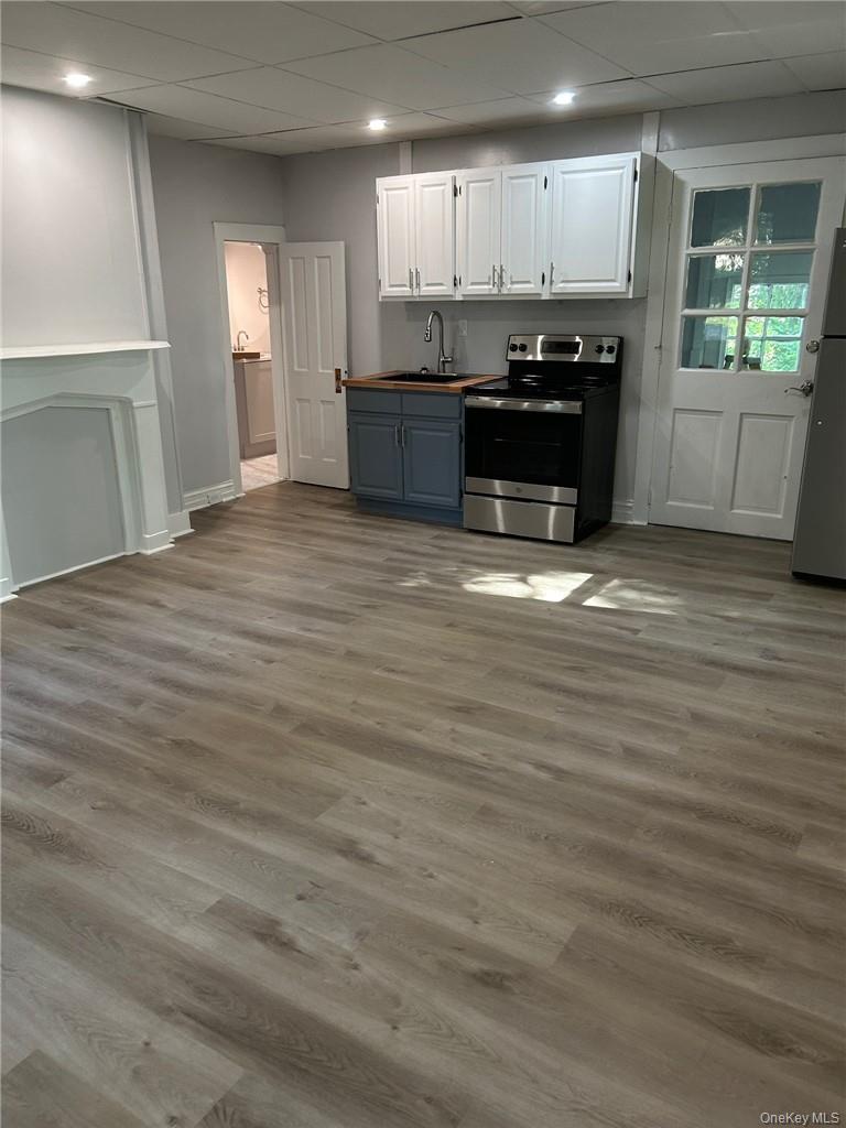 165 South Cross Road, Unit 4 Staatsburg, NY 12580 - Photo 3 of 12 Kitchen featuring stainless steel appliances, white cabinets, hardwood / wood-style flooring, and sink