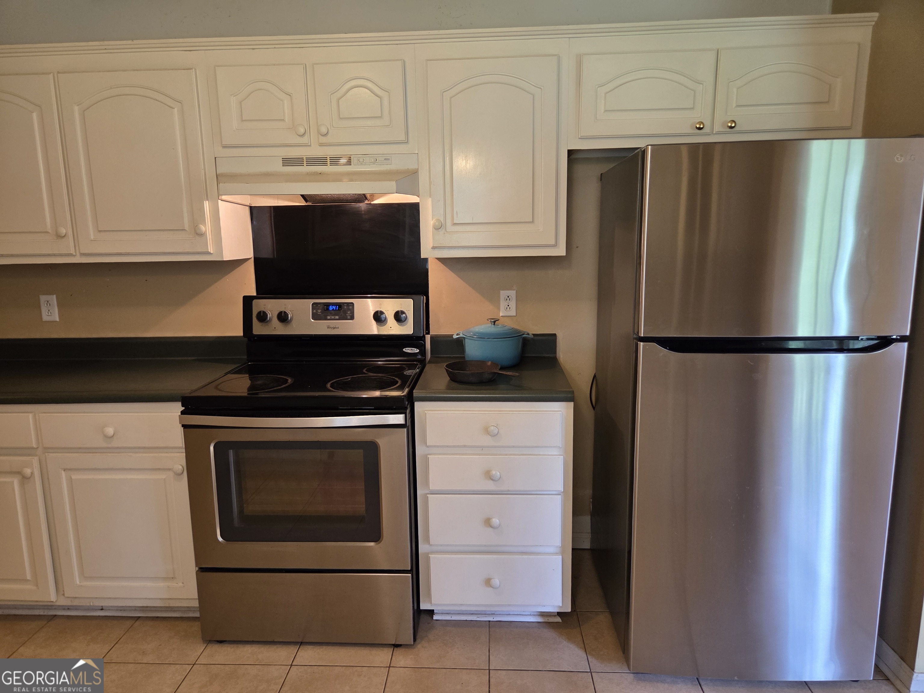 9546 Union Road Metter, GA 30439 - Photo 14 of 45 a kitchen with granite countertop white cabinets and stainless steel appliances