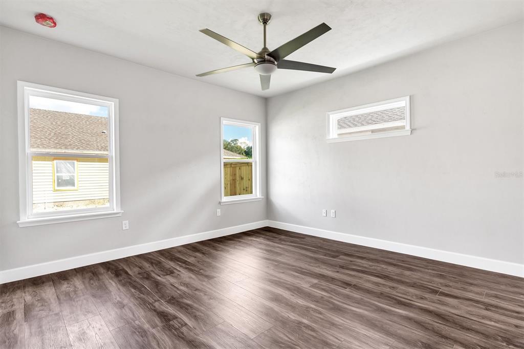 1140 Southwest 67th Street Gainesville, FL 32607 - Photo 30 of 65 a view of empty room with wooden floor and fan