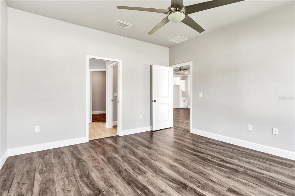 1140 Southwest 67th Street Gainesville, FL 32607 - Photo 31 of 65 an empty room with wooden floor ceiling fan and windows