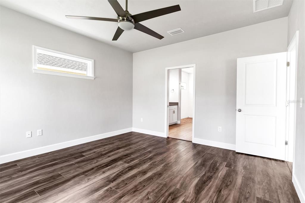 1140 Southwest 67th Street Gainesville, FL 32607 - Photo 32 of 65 a view of an empty room with wooden floor and a ceiling fan