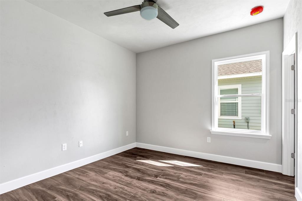 1140 Southwest 67th Street Gainesville, FL 32607 - Photo 42 of 65 an empty room with wooden floor cabinet and windows