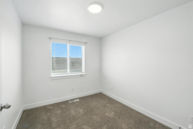 1221 West 1870 South Logan, UT 84321 - Photo 9 of 20 Bright room featuring a window with horizontal blinds, neutral-toned carpet flooring, white walls, white baseboards, and a flush-mount ceiling light