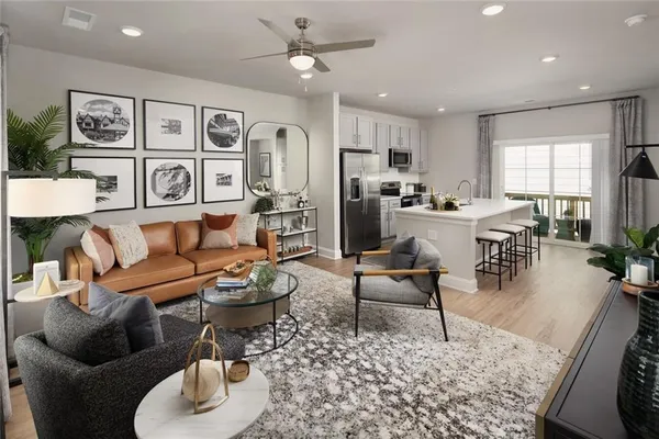 a living room with furniture potted plant and open kitchen view