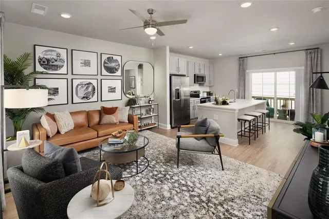 a living room with furniture potted plant and open kitchen view