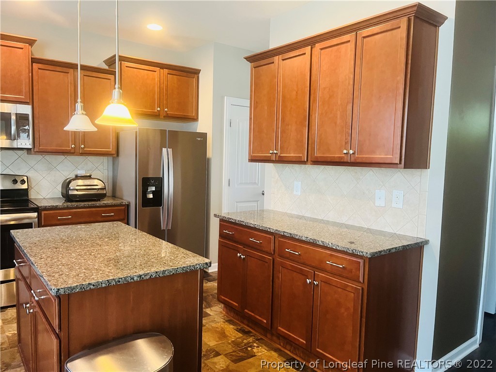 304 River Oak Street Spring Lake, NC 28390 - Photo 13 of 30 a kitchen with a sink a refrigerator and cabinets