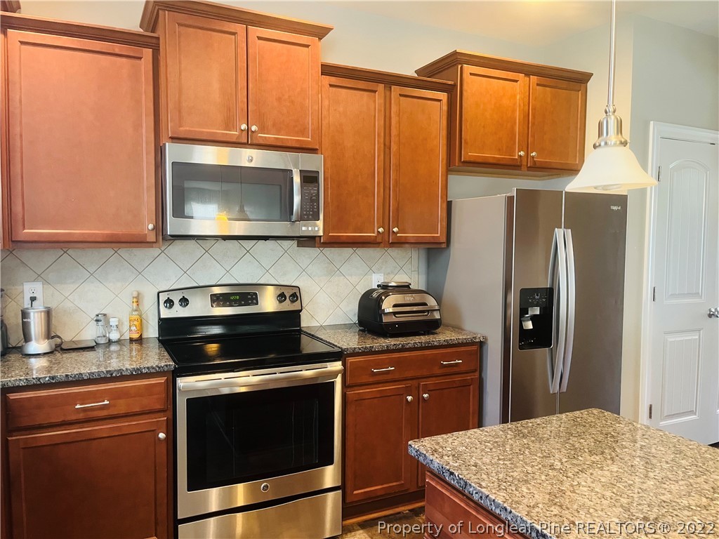 304 River Oak Street Spring Lake, NC 28390 - Photo 14 of 30 a kitchen with stainless steel appliances granite countertop a stove microwave refrigerator and sink