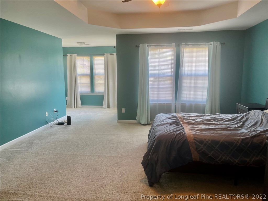 304 River Oak Street Spring Lake, NC 28390 - Photo 21 of 30 a spacious bedroom with a bed and large windows