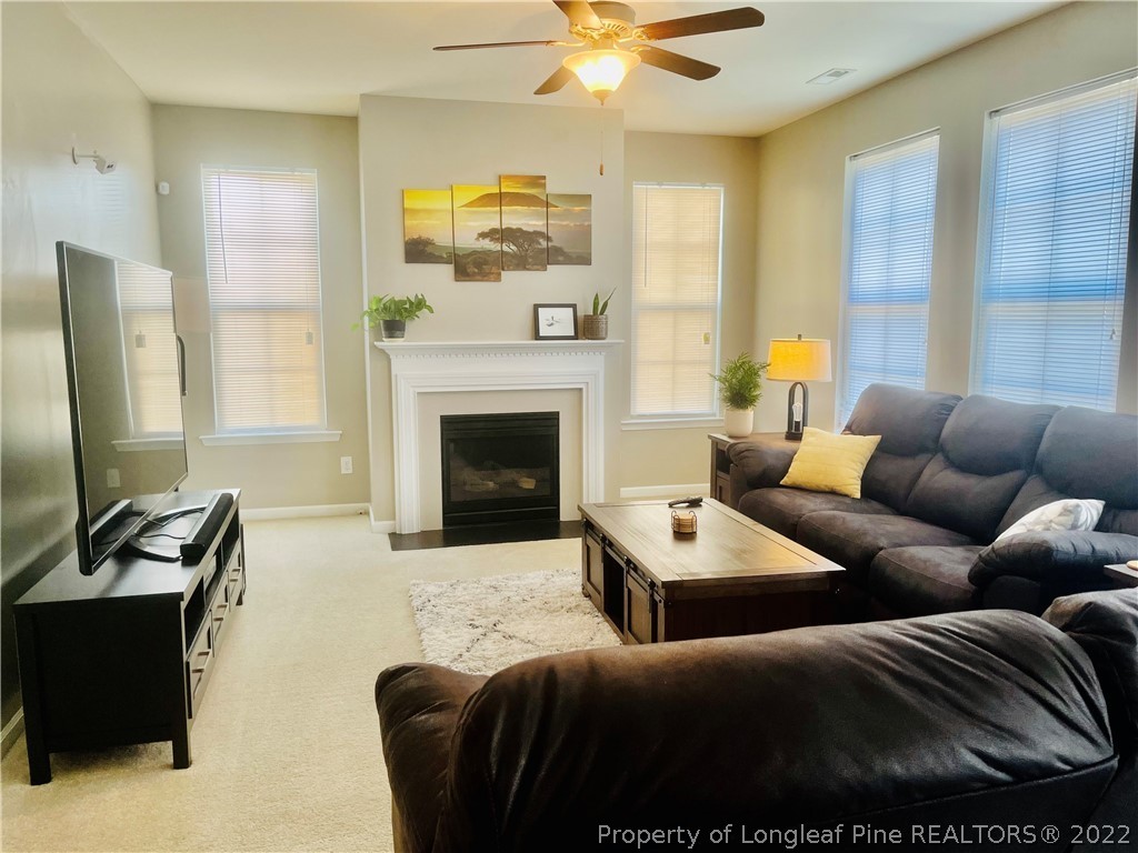 304 River Oak Street Spring Lake, NC 28390 - Photo 4 of 30 a living room with furniture a fireplace and a flat screen tv
