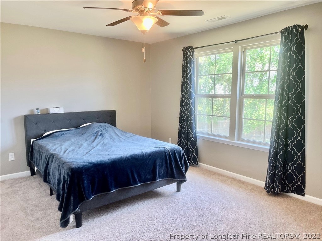 304 River Oak Street Spring Lake, NC 28390 - Photo 6 of 30 a spacious bedroom with a bed and a chandelier