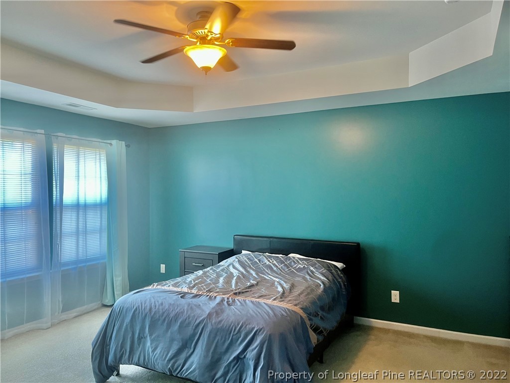 304 River Oak Street Spring Lake, NC 28390 - Photo 8 of 30 a bedroom with a bed and a chandelier fan