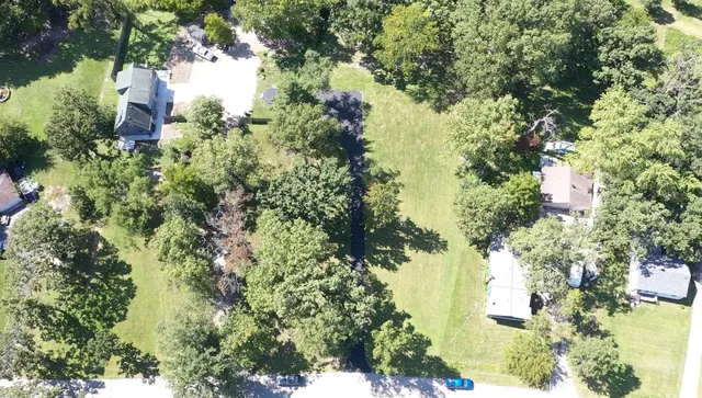 an aerial view of residential house with outdoor space and trees all around
