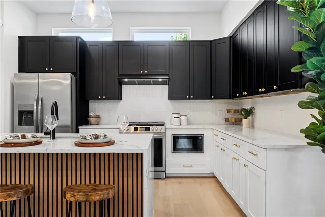 a kitchen with granite countertop a refrigerator stove and microwave