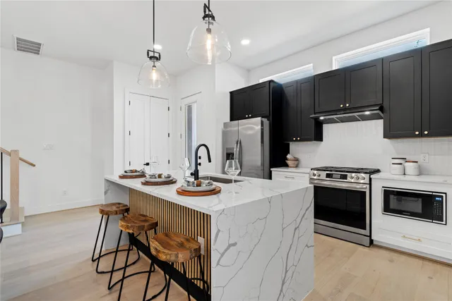 a kitchen with a stove a sink and a refrigerator