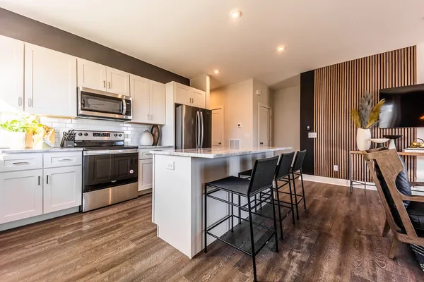 a kitchen with kitchen island granite countertop a stove sink microwave and refrigerator