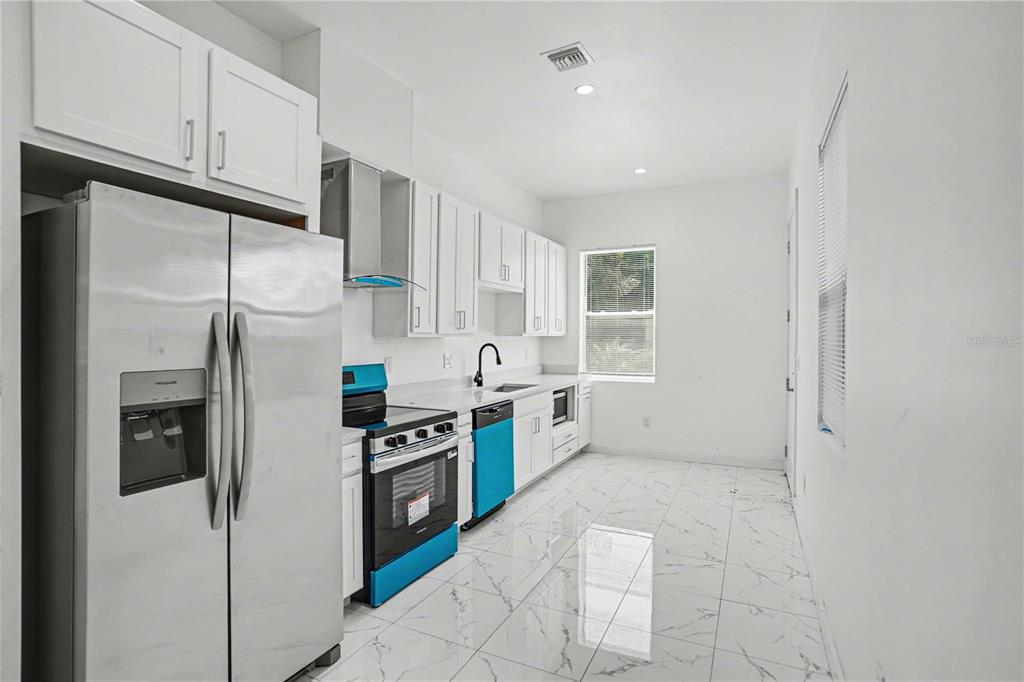 2328 West Spruce Street, Unit A Tampa, FL 33607 - Photo 4 of 15 a kitchen with stainless steel appliances a refrigerator sink and cabinets