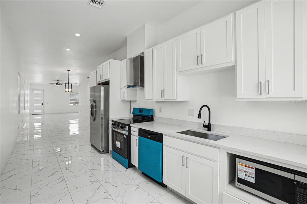 2328 West Spruce Street, Unit A Tampa, FL 33607 - Photo 5 of 15 a kitchen with a sink stainless steel appliances and cabinets