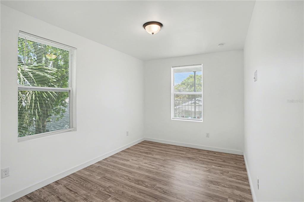 2328 West Spruce Street, Unit A Tampa, FL 33607 - Photo 9 of 15 an empty room with wooden floor and windows