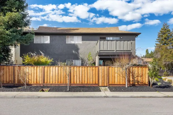 a front view of a house with wooden fence