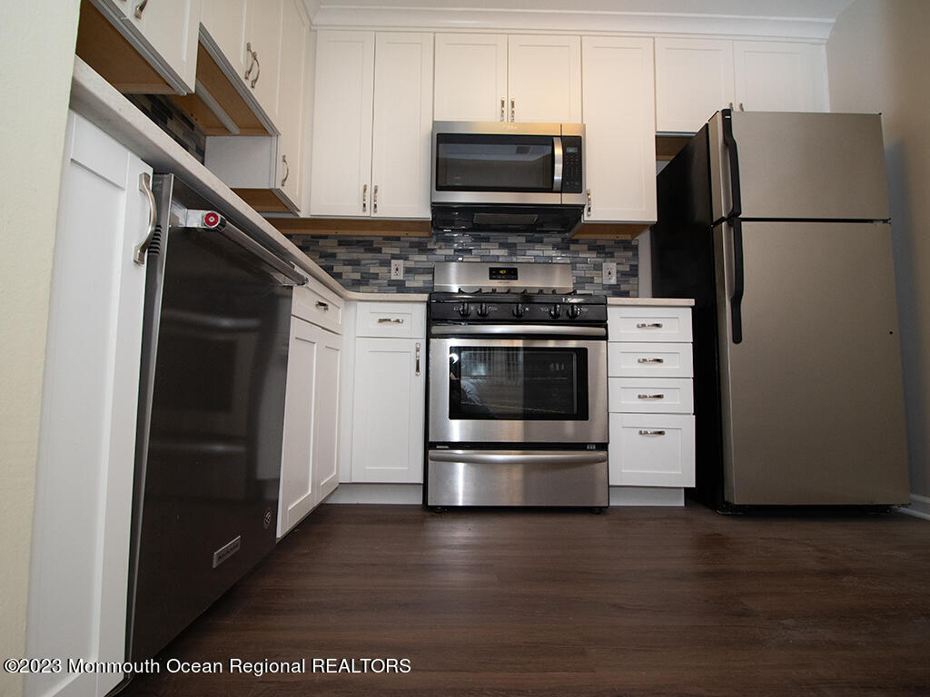459 Magnolia Court Howell, NJ 07731 - Photo 5 of 22 a kitchen with stainless steel appliances and wooden cabinets