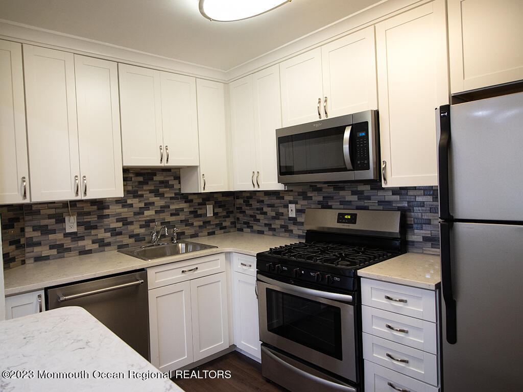 459 Magnolia Court Howell, NJ 07731 - Photo 6 of 22 a kitchen with stainless steel appliances white cabinets and a stove a oven with white countertops