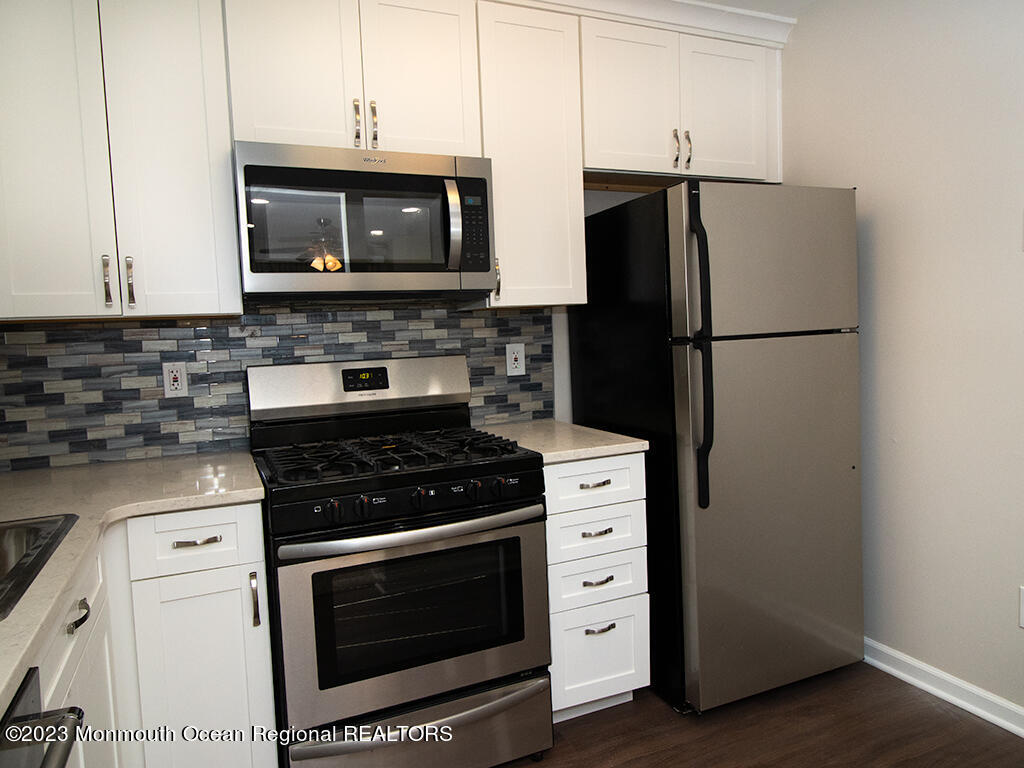 459 Magnolia Court Howell, NJ 07731 - Photo 8 of 22 a kitchen with stainless steel appliances a stove a microwave and a refrigerator