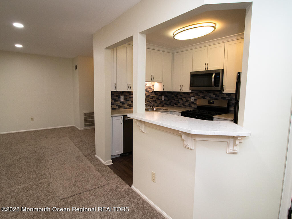 459 Magnolia Court Howell, NJ 07731 - Photo 9 of 22 a kitchen with stainless steel appliances a refrigerator and a stove top oven