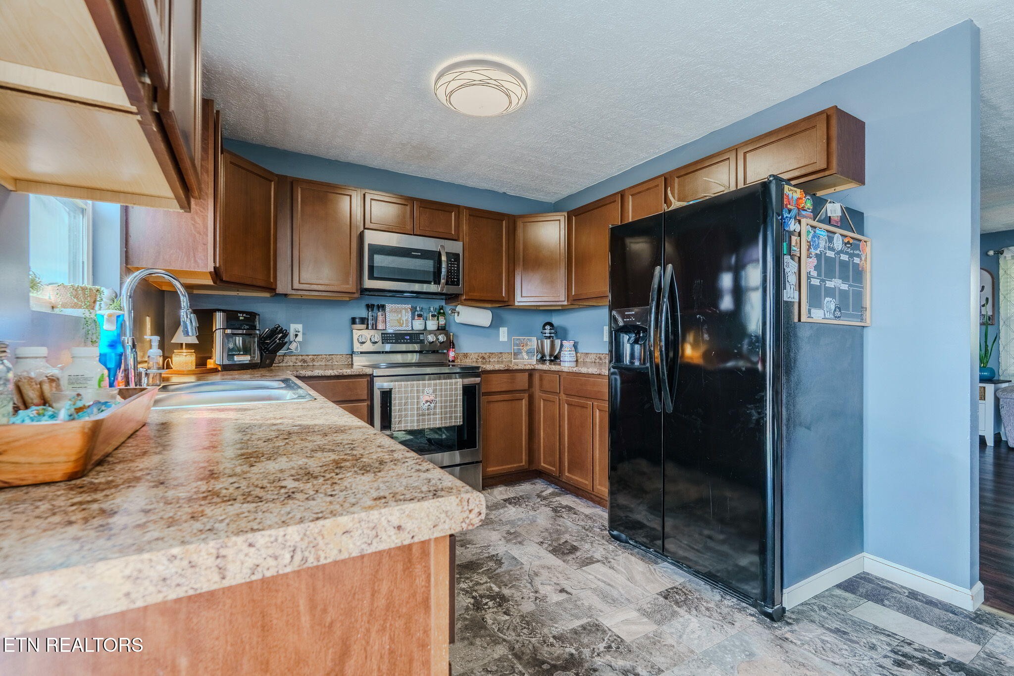 3215 Smith Road White Pine, TN 37890 - Photo 11 of 28 a kitchen with stainless steel appliances granite countertop a refrigerator a stove and a sink with wooden cabinets