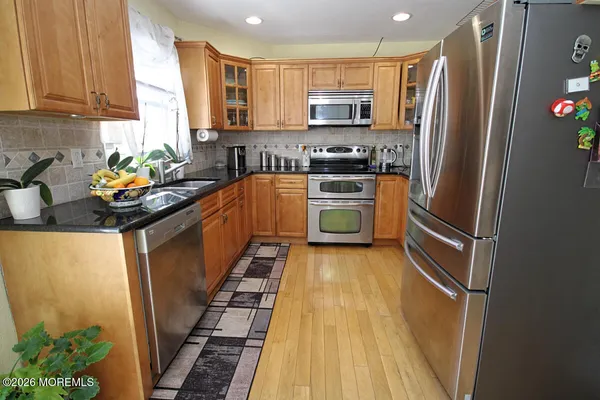 a kitchen with stainless steel appliances a refrigerator sink stove microwave and cabinets