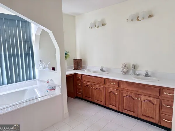 a bathroom with a tub sink and mirror