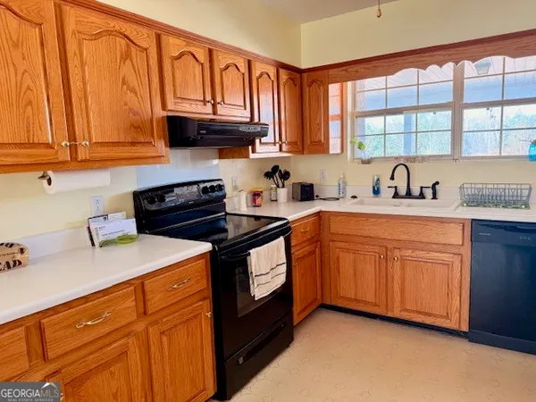 a kitchen with stainless steel appliances granite countertop a sink dishwasher stove and cabinets with wooden floor