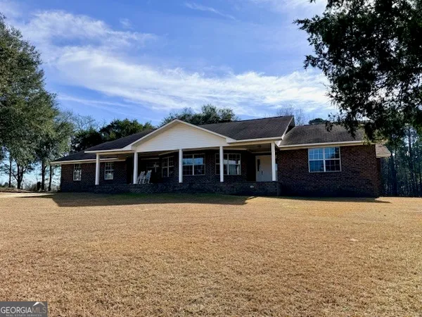 a front view of a house with yard and trees