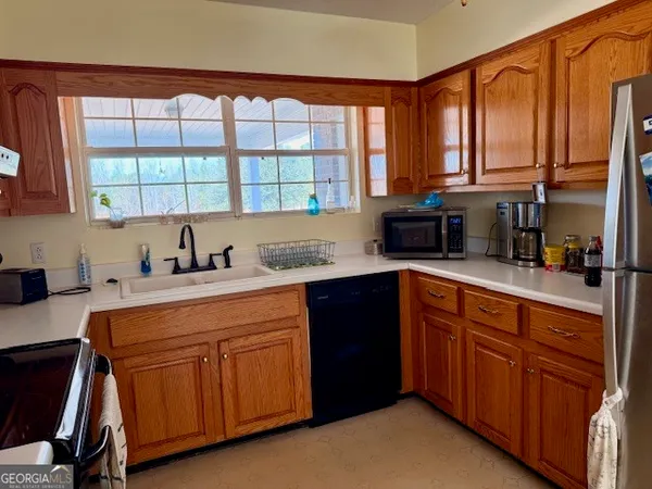 a kitchen with stainless steel appliances granite countertop a sink a stove and cabinets