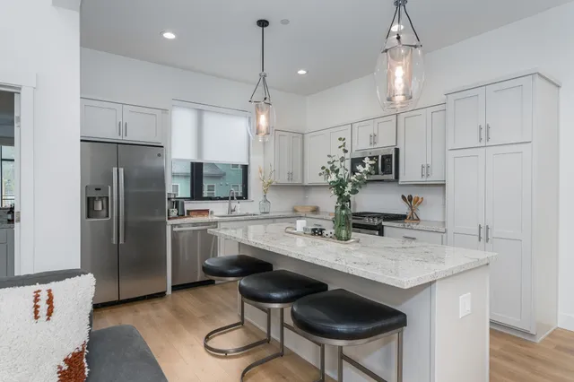 a kitchen with stainless steel appliances granite countertop a sink refrigerator and cabinets