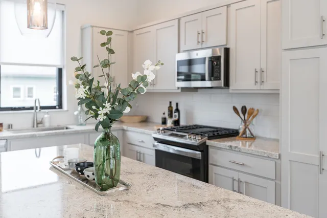 a kitchen with stainless steel appliances granite countertop a sink stove and white cabinets
