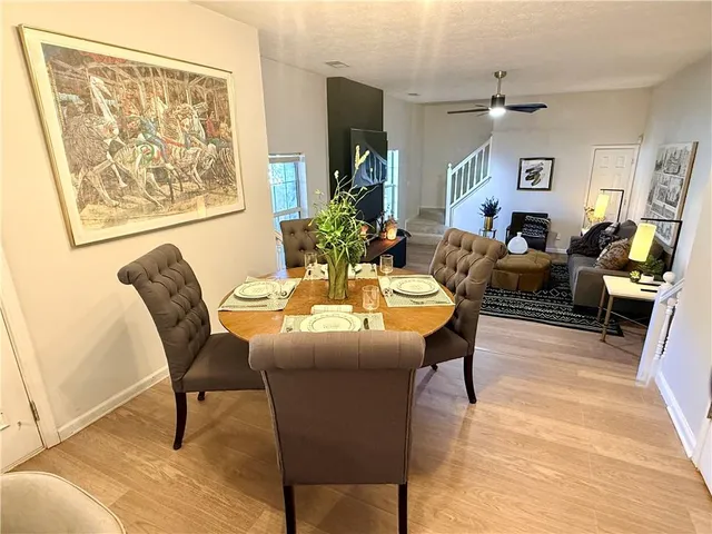 a dining room with wooden floor and a chandelier