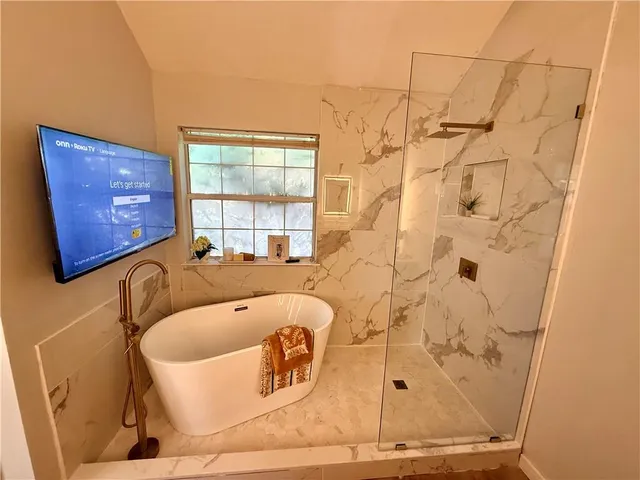 a bathroom with a bathtub and shower