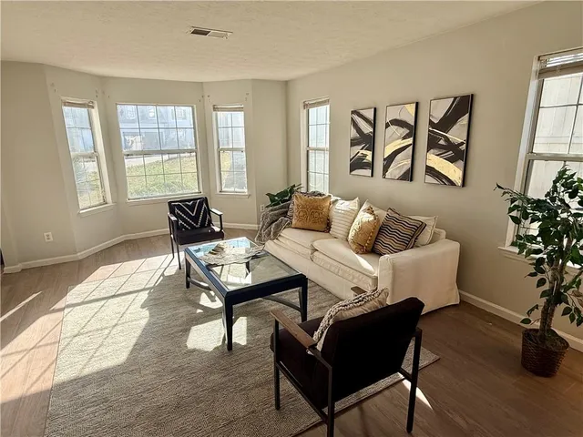 a living room with furniture and wooden floor