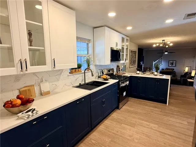 a room with a sink wooden cabinets and living room view