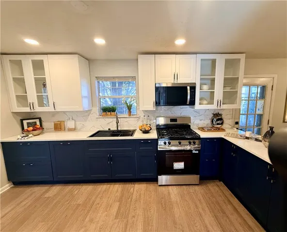 a large kitchen with wooden cabinets and a stove top oven