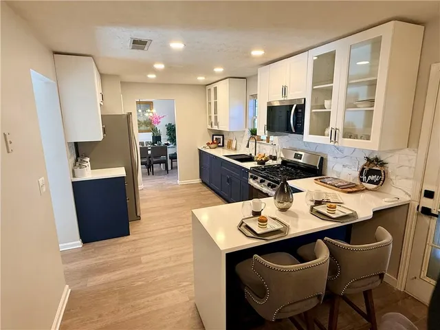 a kitchen with a sink and chairs