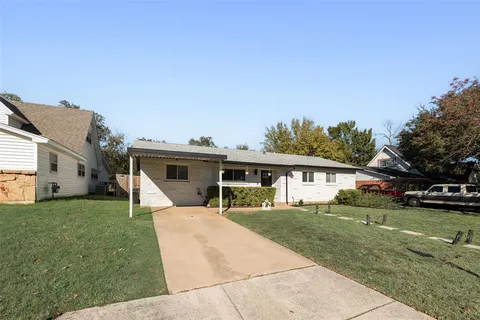a view of a house with a yard and sitting area